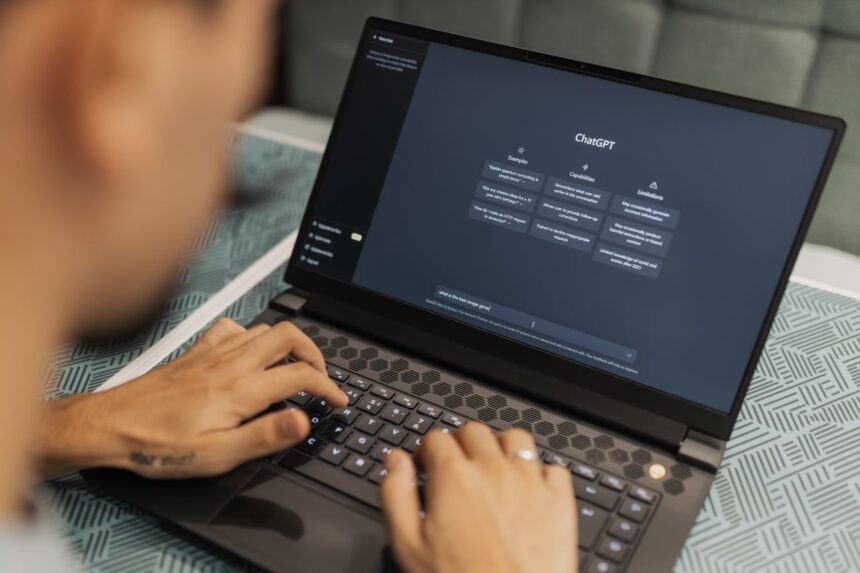 Beginner typing a first prompt into ChatGPT on a laptop at a kitchen table
