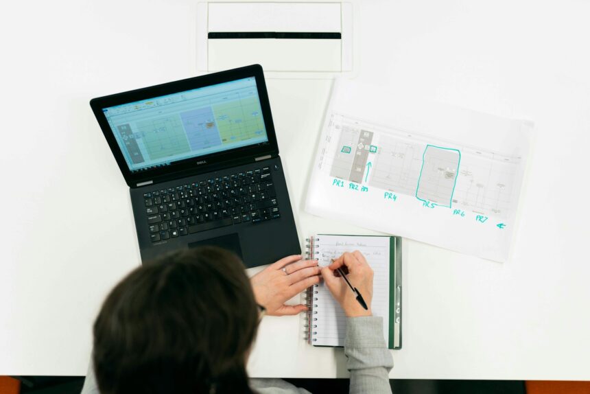 Teacher's laptop displaying AI planning and differentiation tools beside graded papers