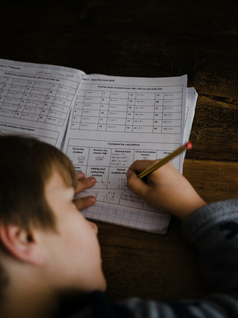 Student completing a timed practice test on paper with a timer running